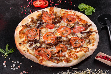 Fresh hot pizza with meat, mushrooms, cheese and tomatoes made in an oven
