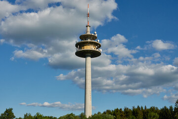 Weather Station in St&ouml;tten, photographed from below, the main subject in the middle of a blue sky and green forest in the early evening.