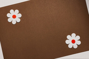 Cardboard sheet. Application of flowers on a sheet of paper. Two flowers of the same color.