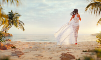 Fototapeta na wymiar Young Happy Carefree Woman Enjoying Beautiful Sunset on the Tropical Beach.