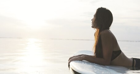 Fototapeta na wymiar Beautiful girl on a surf board in the ocean