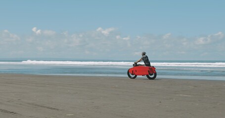 Motorcyclist driving his motorbike on the beach