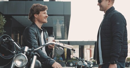 Two friends motorcyclists men meet on street