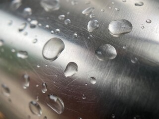 Closeup of raindrops on a steel hand rail.