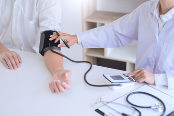 Doctor measuring and checking blood pressure of patient in hospital, Health care and medicine...