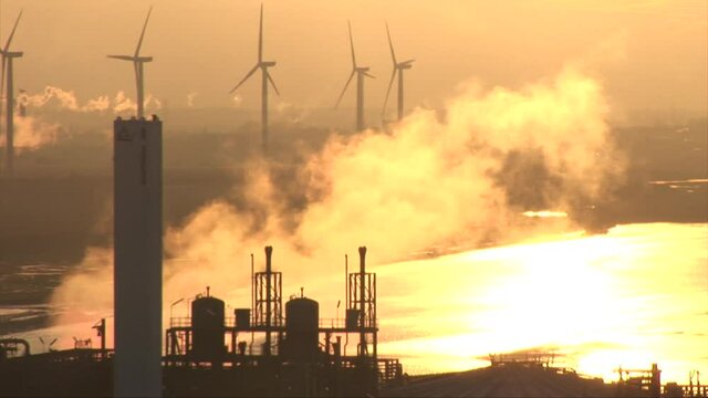 Yellow golden sunset with industry and wind turbines
