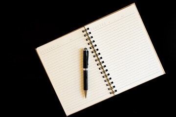 black pen and notebook on a black background, a book for notes, school supplies for study, a set of pens for school