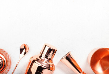 Copper bar tools and accessories for making cocktail. Shaker, jigger, strainer, spoon, tongs, muddler. Alcohol drink and beverages preparation concept. White background, top view, copy space