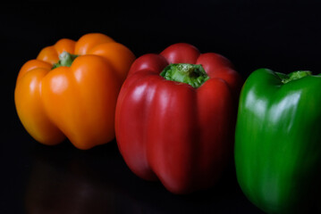 red yellow green pepper on a black table