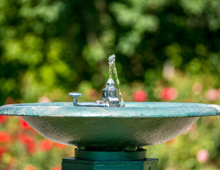 Outdoor water tap or foutain. Drinking water in the park on a  background with blurred bokeh  red...