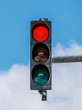 Traffic light against blue sky showing the color red.