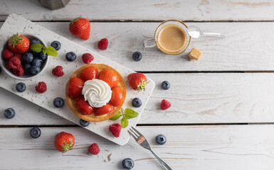 Fototapeta na wymiar Homemade dessert strawberry pie with raspberry's and blue berry's and a coffee.Top view.