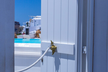 white door opened showing view of villas in santorini greece