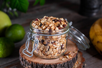 Home granola in a glass jar. Selective focus, concrete background