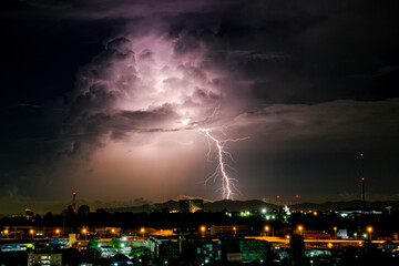 Cloudy with Bright lightning bolt strikes in the rural landscape of small city and satellite station