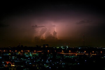 Cloudy with Bright lightning bolt strikes in the rural landscape of small city and satellite station