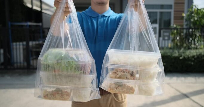Food Delivery man handing plastic bags from supermarket to client customer express grocery covid19 new normal