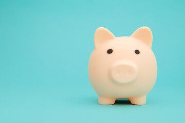 Pink piggy bank on blue background space for text. Savings concept.