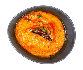 Indian cuisine - top view of portion of yellow Dal Tadka (spicy smooth and creamy chowder from lentils with curry) in black bowl isolated on white background