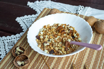Healthy muesli with milk and nuts in a plate on a wooden table. Healthy lifestyle