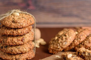 homemade oatmeal cookies with dates, peanuts, coconut shavings on a wooden background, macro close-up. broken cookies in the foreground. space for text
