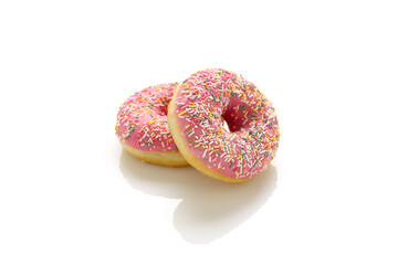 Two donuts with pink icing and colored sprinkles on a white background.