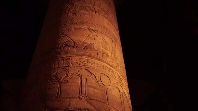 Close up hieroglyphics on Kom Ombo temple column at night uplight