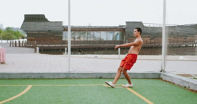 Football amateur player sends corner kick, guy plays football topless.