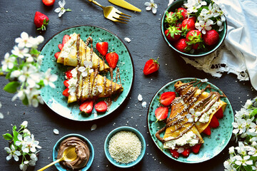 Pancakes with strawberries and chocolate. Spring still life with a sweet breakfast.