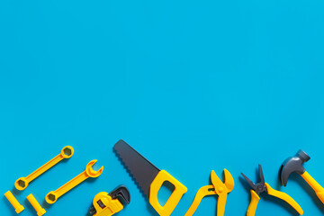 Toys background. Top view of toy tools on blue background