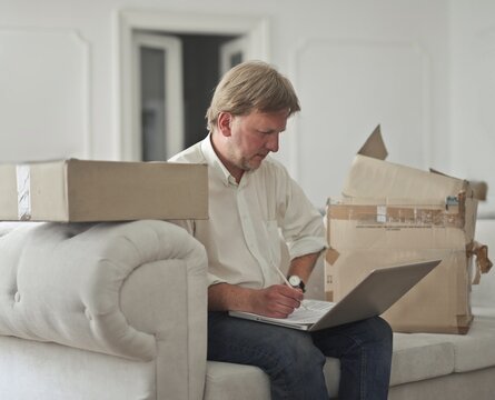 man at home prepares boxes for shipping