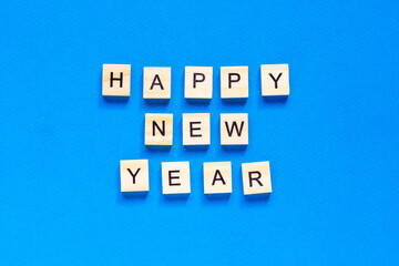Happy New year written in wooden letters on a blue background. Happy new year 2021. flat layout. space for text. top view.