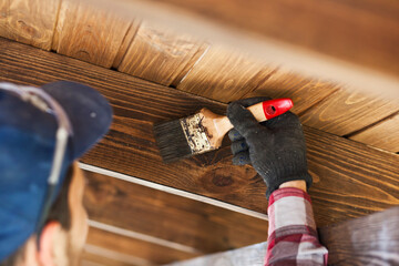 The worker is painting the wooden terrace