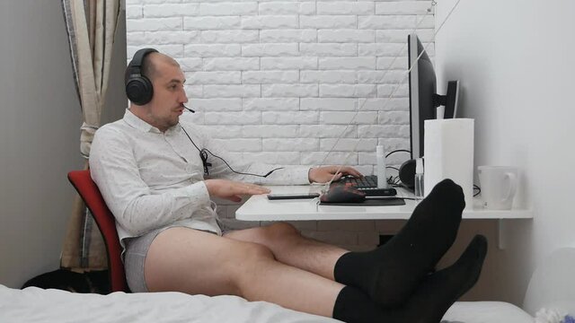 Telework. Freelance. A businessman in a shirt, shorts and underpants conducts a video conference on a computer in the home office. Freelance
