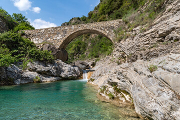 Fototapeta na wymiar Stone bridge in mountains, Ligurian Alps, northwestern Italy