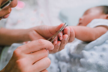 Close up photo for the mother cutting the finger nails of the baby.