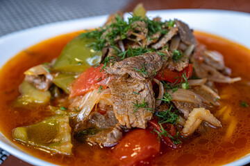 Closeup Lagman Dish with Lamb. Plate with Asian dish on the table.