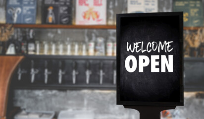 Obraz premium Come in We’re Open’ on cafe waiter standing in front of coffee shop vintage retro sign Open sign at coffee