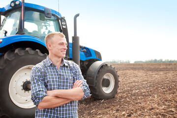Young attractive man near a tractor. Concept of agriculture and field works. © murika
