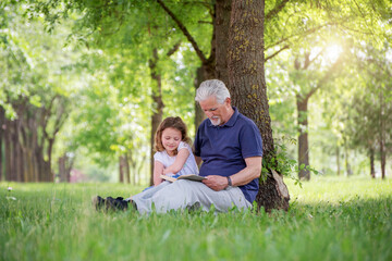 Grandfather and his granddaughter  playing  outdoors