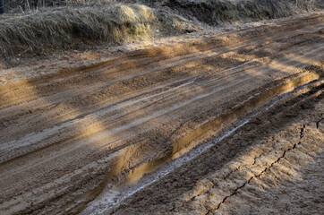 Broken dirt road after heavy rain. Swampy lagoon of a road demonstrates the most common problem in...