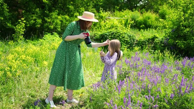 mom photographs daughter in a field of purple flowers.