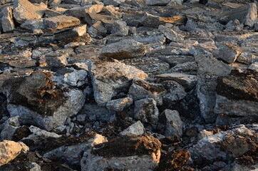 Broken pieces of asphalt at a construction site. Recycling and reuse crushed concrete rubble, asphalt, building material, blocks. Crushed сoncrete Background. Road repair, replacement of old pavement