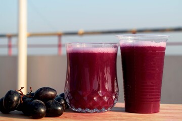 A glass of fresh grape juice close view. Delicious grape juice ready to drink. 