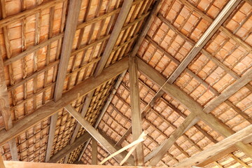 Thai style under roof of ancient building, brown wood construction and roof tiles of under roof, Thailand.