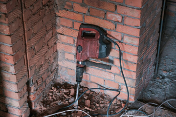 Professional tool for drilling. Electric drill on red brick wall background