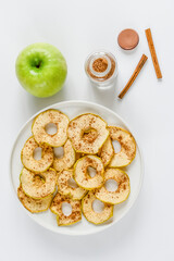 Chips from apples with cinnamon on a white background. Dried and fresh apples on a white background.