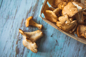 Chantarelle. Raw wild chanterelles mushrooms on old rustic background. Organic Fresh chanterelle border background on a table. Label design. Vegan food. Yellow chanterelle (cantharellus cibarius).