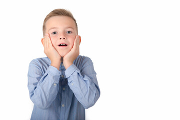 A surprised boy is holding his hands at his face; isolated on the white background