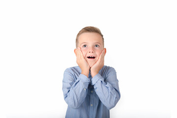 A surprised boy is holding his hands at his face; isolated on the white background